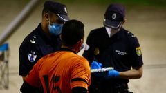 Dos polic�as auton�micos en A Coru�a, identificando a un vecino que practicaba deporte en grupo sin mascarilla