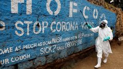 Un trabajador desinfecta un mural contra el coronavirus en Nairobi, Kenia