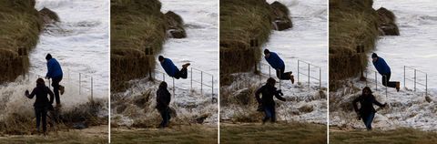 Una pareja sorprendida por un golpe de mar en la playa de Esteiro, Xove