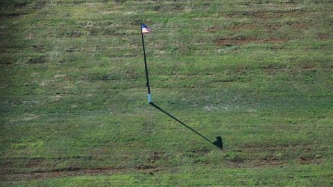 Una bandera estadounidense en medio de las fosas comunes de miles de enterrados, en Hart Island. 