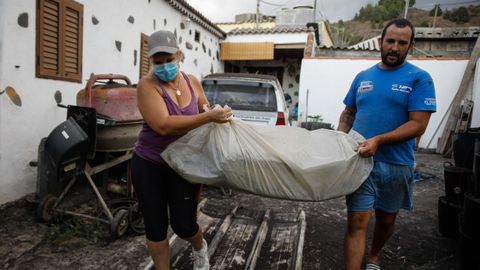 Un hombre y una mujer sacan sus pertenencias en Tajuya, una de los barrios desalojados el viernes tras el repunte de la actividad volc�nica