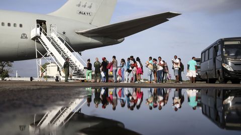 Migrantes venezolanos suben a una avi�n de las fuerzas a�reas brasile�as en el aeropuerto de Boa Vista para dirigirse a Manaos y Sao Paulo