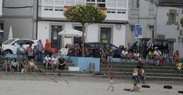 Espectadores siguiendo desde la playa ayer la regata de bateles, una de las actividades de fiesta. 