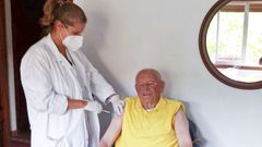 Lorena Gondar, enfermera sustituta del centro de salud de Campo Lameiro, este viernes, vacunando en su casa a Elaudino Barros, de 95 a�os