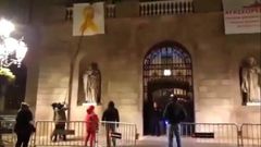 Un comando antilazos descuelga un lazo amarillo del Ayuntamiento de Barcelona