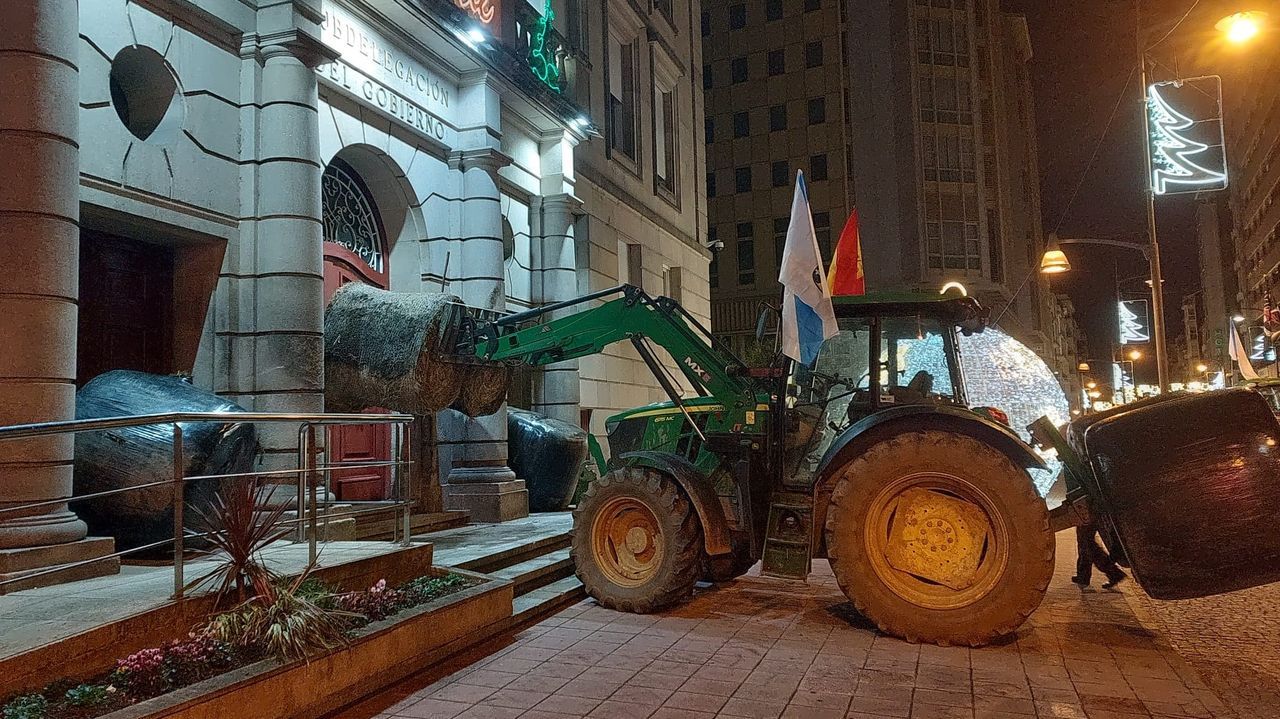 Los manifestantes de la tractorada de Ourense bloquean la entrada de la Subdelegación con rollos de paja y un vehículo