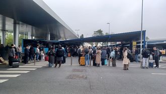 Pasajeros en Alvedro esperando por un autob&uacute;s que los lleve a Santiago para poder coger el vuelo de vuelta a Madrid, que fue desviado a Lavacolla este viernes por la niebla