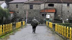 Un peregrino del Camino de Invierno cruza el Mio por el puente de Belesar entre O Saviao y Chantada