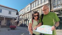 Una pareja de turistas consultando un mapa en el casco antiguo de Chantada