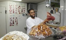 Hassan Elhariri, en el mostrador, junto a una pieza de carne y dulces tradicionales. 