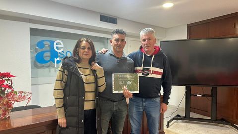 Premiados del sorteo navide�o de la Asociaci�n de Empresarios de Ribeira recogiendo su vale de mano del presidente, Francisco Mart�nez