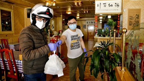 Xiao, con un repartidor en su local de Vigo, centrado ahora en la venta a domicilio