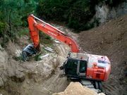 Una m�quina excavadora junto a los restos del castro.