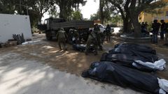 Soldados recogen a los fallecidos en el kibutz de Kfar Aza.
