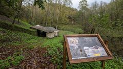 Un panel informativo de la ruta frente a un antiguo molino que forma parte del itinerario