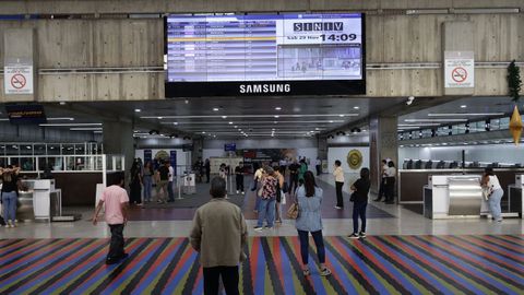 Varias personas observan una pantalla con la programacin de los vuelos el sbado en el Aeropuerto Internacional Simn Bolvar en Maiqueta, cerca de Caracas.