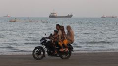Una familia en moto circula por una playa de Bandar Ab�s, en el sur de Ir�n, frente al estrecho de Ormuz