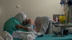  Una trabajadora sanitaria atiende a un paciente con coronavirus en la unidad de reanimaci�n (REA) del Complejo Hospitalario Universitario de Ourense (CHUO), este mi�rcoles. Agotados pero al pie del ca��n un d�a tras otro. As� est�n en cr�ticos. No en vano, es la mejor definici�n del estado de �nimo de los profesionales sanitarios que lidian con los contagios de la covid-19, tanto desde Cuidados Intensivos (UCI) como en REA. 