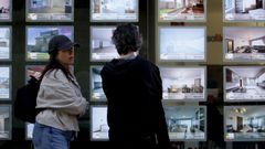 Vecinos lucenses observan el escaparate de una inmobiliaria.