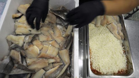 1 - El pescado llega limpio de las lonjas de Vigo y A Coru�a. En la cocina lo cortan en raciones que se distribuyen en bandejas de horno con arroz y tomate.