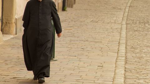 Cura caminando por la calle en una imagen de archivo