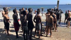 J�venes migrantes hacen cola para ducharse en la playa del Trampol�n, en Ceuta