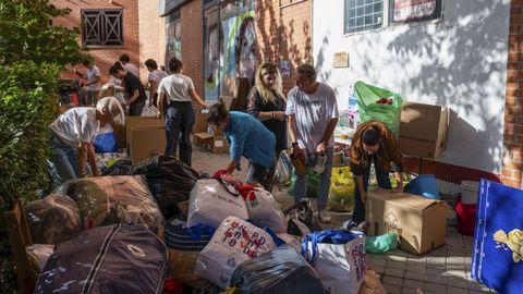 Grupos de personas ayudan en la recogida de palas, cubos, alimentos no perecederos, agua, productos primera necesidad y ropa para enviar a Valencia