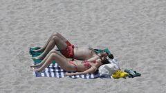 Una pareja al sol en la playa de Riazor