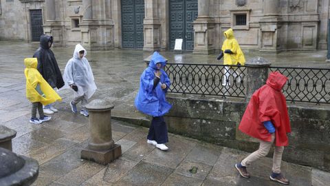 Un grupo de turistas recorriendo bajo la lluvia el centro de Santiago la semana pasada.