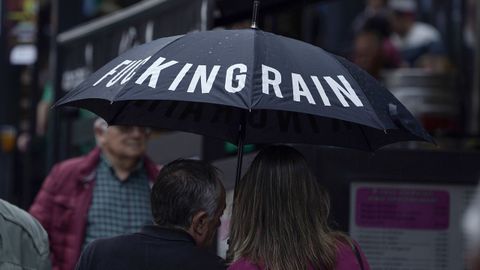 Una pareja se protege de la lluvia con un paraguas en una calle del centro de Oviedo