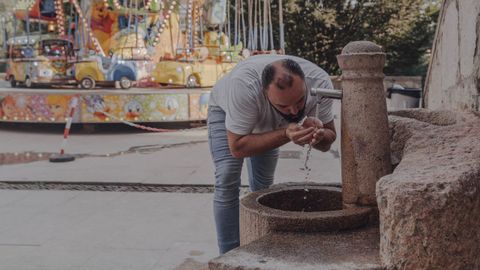 Un hombre trata de refrescarse en una fuente en las calles de Ourense. 