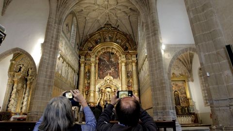 Unos visitantes ante el retablo mayor durante la reapertura de iglesia, el pasado octubre