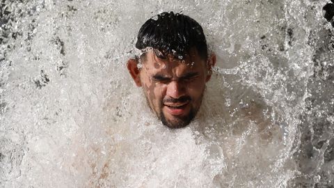 Un hombre se refresca en el aliviadero de una presa en Uharte (Navarra)