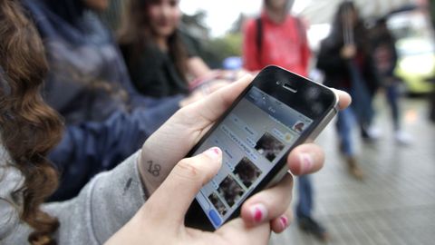 Imagen de archivo de j�venes viendo fotograf�as en sus tel�fonos