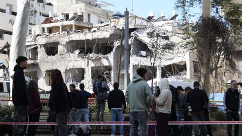 Varias personas observan un edificio da�ado en la ciudad de Tel Aviv durante el contraataque de Ir�n.