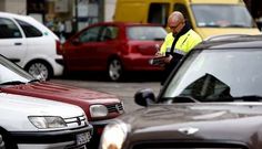 Los vigilantes del estacionamiento siguen apuntando a mano las matr�culas de los veh�culos mientras no llueve.