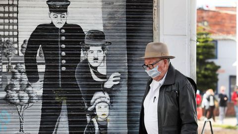 Un hombre, con mascarilla, camina por una calle de Bogot