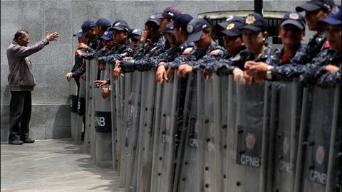 Un hombre se dirige a los agentes del Sebin apostados en el exterior del Palacio Legislativo de Caracas