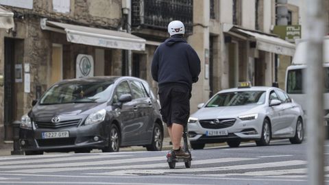 Imagen del pasado mes de agosto de un usuario de patinete con casco en una calle de Santiago.