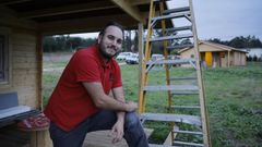 Guillem Garca, coas estruturas das tres primeiras cabanas que xa levantou.