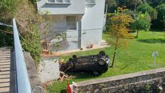 El coche qued� volcado con el techo sobre una finca tras precipitarse desde el puente en A Ponte do Porco (Paderne).