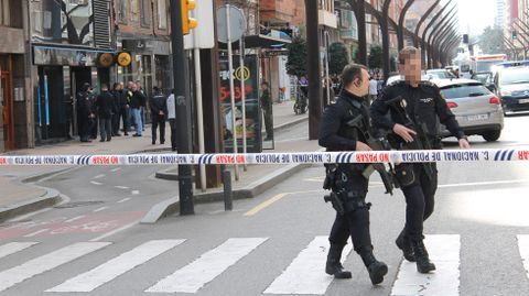 Dos agentes, con ametralladoras, se alejan de la entidad donde a�n estaba el atracador