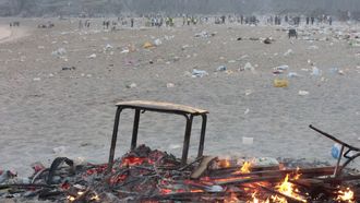 Restos de hoguera y basura en la playa del Orz&aacute;n tras San Xo&aacute;n