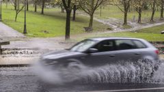 Un coche circula en medio de una lluvia intensa.