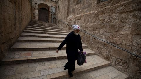 Una monja con mascarilla camina dentro de la iglesia del Santo Sepulcro, en Jerusaln, este Jueves Santo