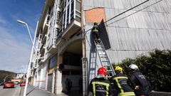 Bomberos de Viveiro retirando una chapa desprendida en un edificio de Xunqueira