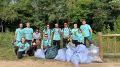 Los voluntarios que participaron en la jornada, con la basura recogida