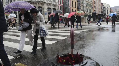 Un grupo de personas con paraguas en el centro de Oviedo