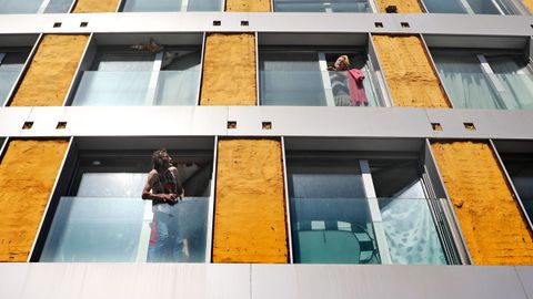 Dos okupas hablan entre ellos desde las ventanas de un edificio tomado en Vigo y que fue desalojado por la Policía