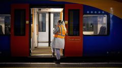 Una trabajadora, en la entrada de un vag�n vac�o en la estaci�n de Waterloo, en Londres